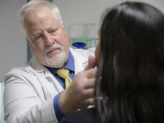 mature white physician examining female patient.