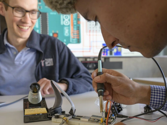 student testing microchip while instructor observes