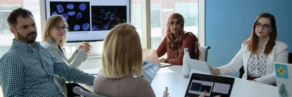 Genetic counselors in a discussion around a table