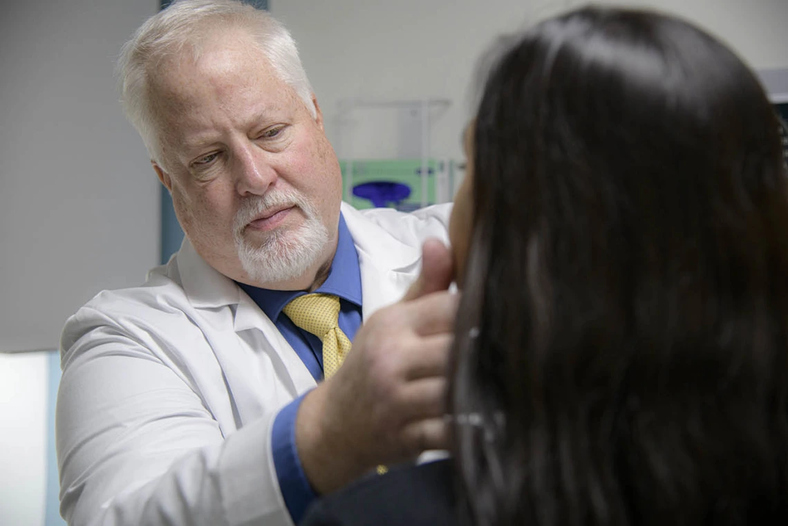 mature white physician examining female patient.