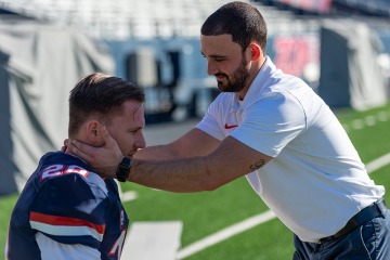 Physical therapist with football player on field