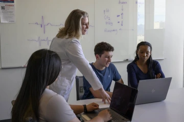 Professor providing feedback to student group