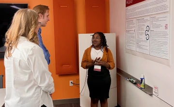 E'Lashae Richards-Scott discusses her poster with AGA attendees.